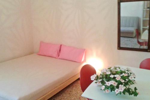 a small room with a couch with a pink pillow at Casa Romantica in Sorso