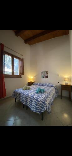 a bedroom with a bed with a blue and white comforter at Samarighouse in Putzu Idu