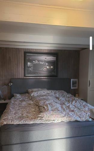 a bedroom with a large bed with a picture on the wall at Cabin and Guest house in Haugesund