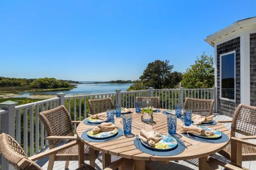 a table on the deck with a view of the water at Waterfront Escape Game Room Dog Friendly in Chatham