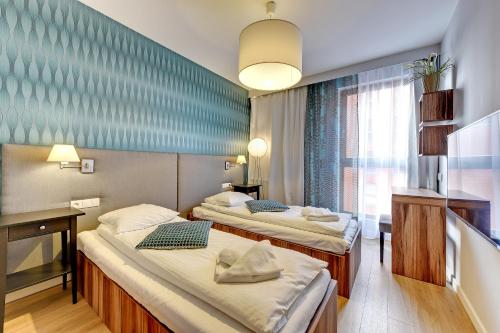 Habitación de hotel con 2 camas y ventana en Staywin Dream Island, en Gdansk