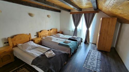 a bedroom with two beds and a window at The Brothers House Bran in Bran