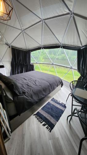 a bedroom in a igloo tent with a bed and a chair at Dôme Romanov in Saint-René-de-Matane