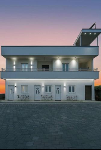 a large white building with benches in front of it at Sunlake Villa in Tirana