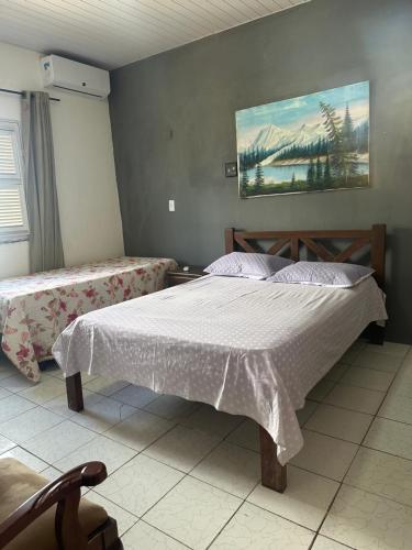 a bedroom with a bed and a painting on the wall at Casa Harmonia in Trairi