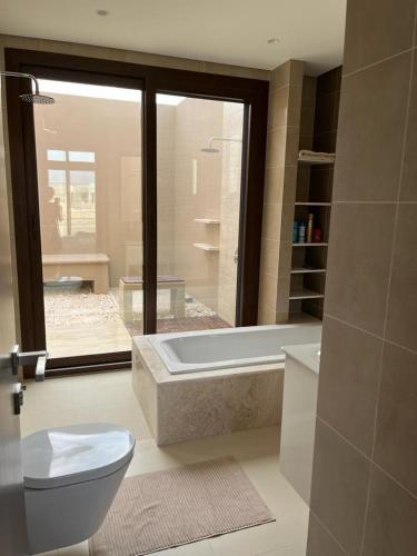 a bathroom with a tub and a toilet and a sink at Luxury Salalah Villa in Salalah