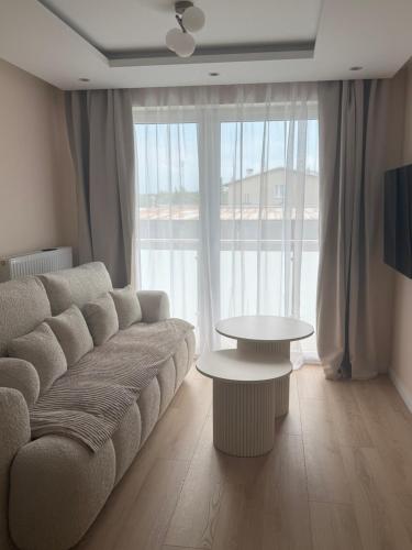 a living room with a couch and a table at Apartament Baltic Pearl in Ustka