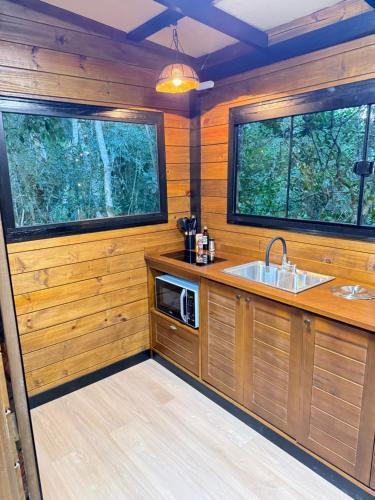a kitchen with a sink and two large windows at Sora Bubble in Angelina