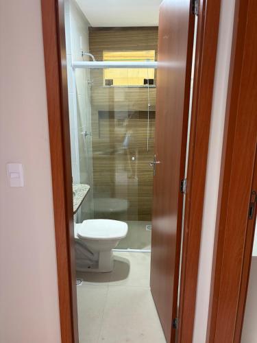 a bathroom with a toilet through a glass door at Laguna Sun Set in Salinópolis