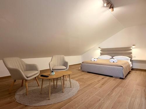 a bedroom with a bed and two chairs and a table at Šaravanja in Bibinje
