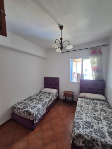 a bedroom with two beds and a window at Jawhara smir 2ET vue piscine in M'diq