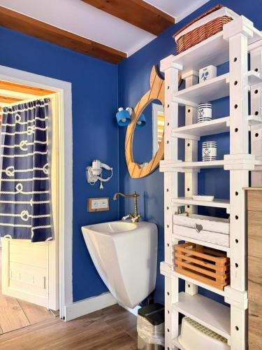 a bathroom with a blue wall and a white shelf at Dom Prowansalski in Jaworzynka