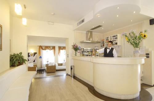 a man standing behind a bar in a room at Hotel Europa in San Bartolomeo al Mare