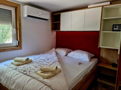 a small bedroom with a bed with towels on it at LuxMobil in Grebaštica
