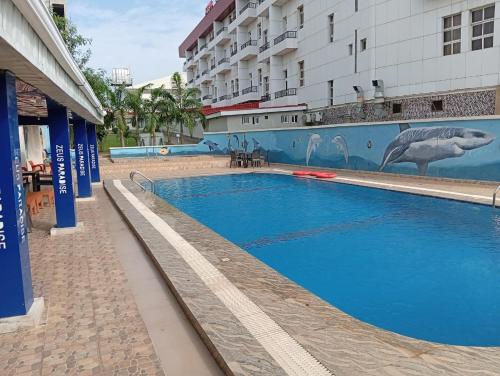 a swimming pool in front of a building at Zeus Paradise Hotel Abuja in Abuja