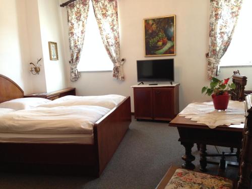 1 dormitorio con cama, mesa y TV en Gasthof Mitter en Haag