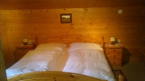 a bedroom with two beds in a wooden wall at Simiterhof in Matrei in Osttirol