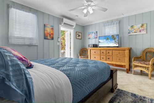 a bedroom with a bed and a flat screen tv at Prime Downtown Location - Truman Little Cozy Cottage in Key West