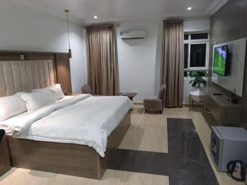 a bedroom with a large bed and a television at Zeus Paradise Hotel Abuja in Abuja