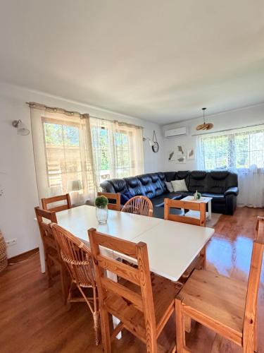 a living room with a table and chairs and a couch at Mazurska Oaza in Pisz