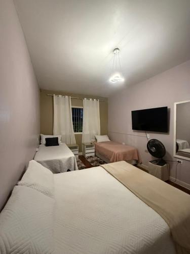 a bedroom with two beds and a flat screen tv at Sobrado completo, confortável e bem localizado in Santo André