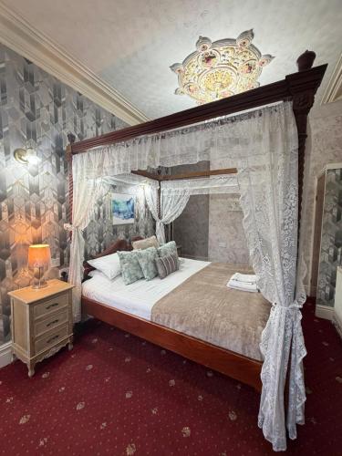 a bedroom with a canopy bed with a chandelier at The Trafalgar in Blackpool
