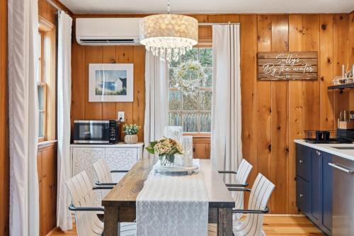 a dining room with a table with white chairs at Charming Cape Cottage in Dennis Port in Dennis Port