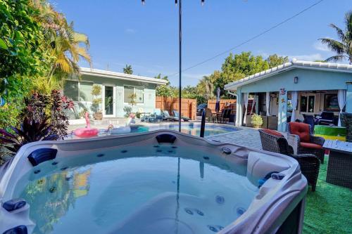 a hot tub in a yard with a house at Caribbean Paradise Retreat Private Pool, Outdoor Kitchen & Jacuzzi in Fort Lauderdale