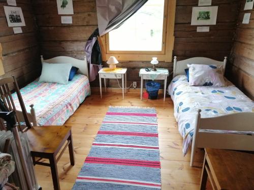 a room with two beds and a window at Yläpihan Tila in Valtimo