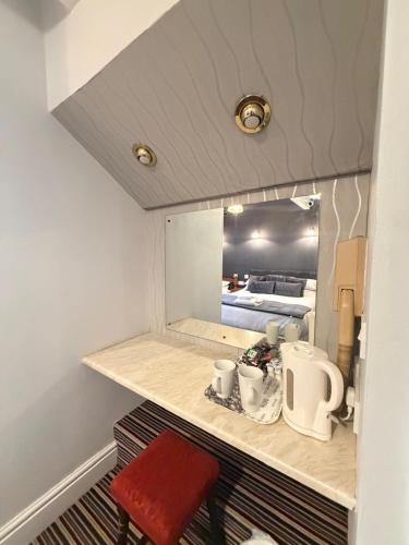 a small kitchen with a mirror and a red stool at The Trafalgar in Blackpool