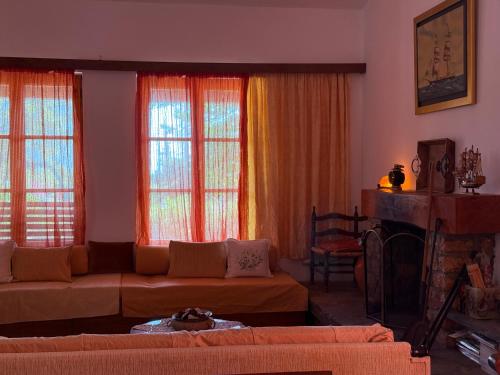 a living room with a couch and two windows at Casa Kaikos in Sevastí