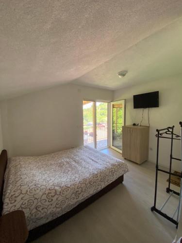 a bedroom with a bed and a flat screen tv at Villa D&M in Ohrid