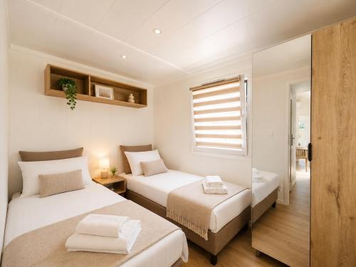 a bedroom with two beds and a window at Domki nad rzeką Narew in Ploski