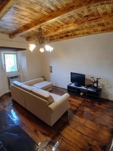 a living room with a couch and a television at Eva house 1 in Fanano