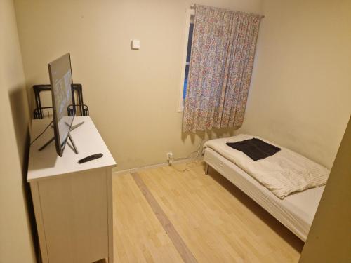 a room with a bed and a desk with a window at God søvn in Lillestrøm