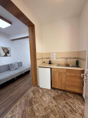 a kitchen with a sink and a couch in a room at Ajan Apartments in Ulcinj