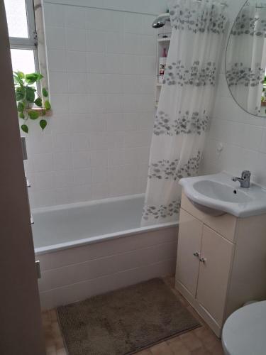 a bathroom with a white tub and a sink at Apartamento Milo in Loures
