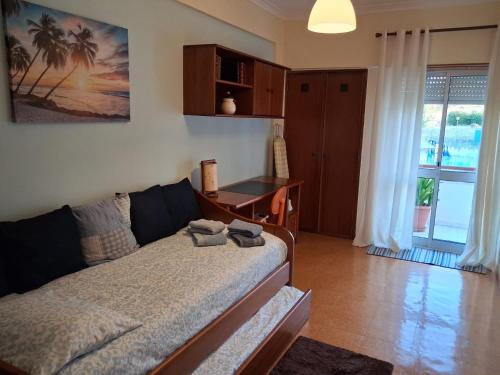 a living room with a couch and a table and a desk at Apartamento Milo in Loures