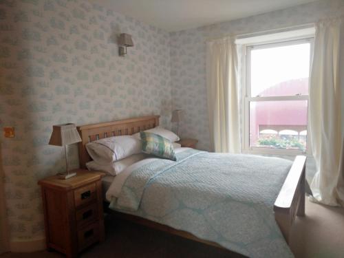1 dormitorio con cama y ventana en The Old Medical Hall, en Castletownbere
