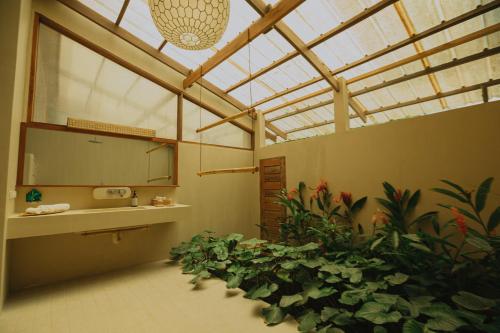 a bathroom with a bunch of plants in a room at Schönhouse Villa Siargao in General Luna