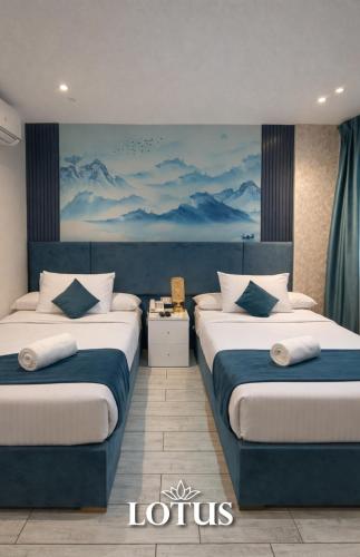 two beds in a room with a painting on the wall at Lotus Hotel l Downtown Cairo Sq in Cairo