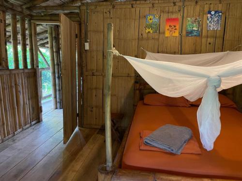 a bed in a room with a net at Maskani Wasi in Lago Agrio