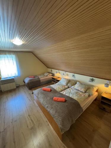 a bedroom with two beds and a wooden ceiling at Manna Igal Apartman in Igal