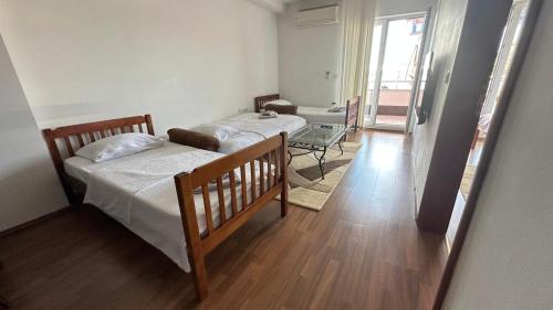 a bedroom with two beds and a living room at Riverside Apartment in Struga