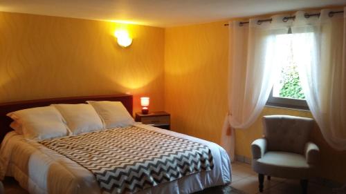 - une chambre avec un lit, une chaise et une fenêtre dans l'établissement Chez Annie, à Saint-Avit-Rivière