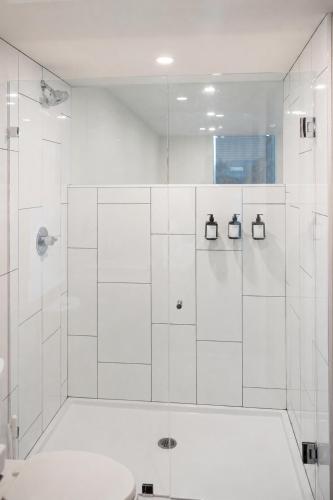 a white bathroom with a shower and a toilet at Ida Phoenix in Phoenix