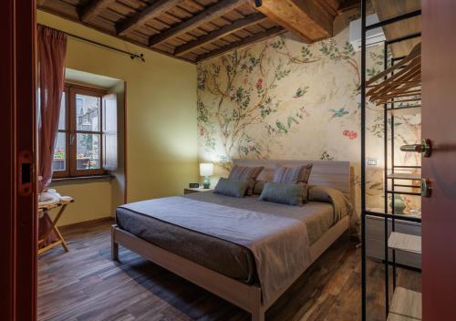a bedroom with a bed with a floral wallpaper at B&B Locanda Cistercense in San Martino al Cimino