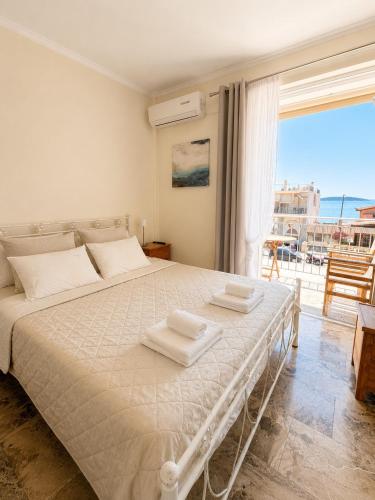 a bedroom with a white bed with a view of the ocean at Farniente Tolo in Tolo