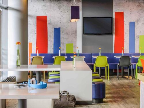 a conference room with tables and chairs and a tv at Ibis Budget Sallanches in Sallanches
