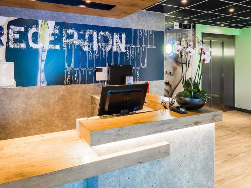 a reception desk with a computer on top of it at Ibis Budget Sallanches in Sallanches
